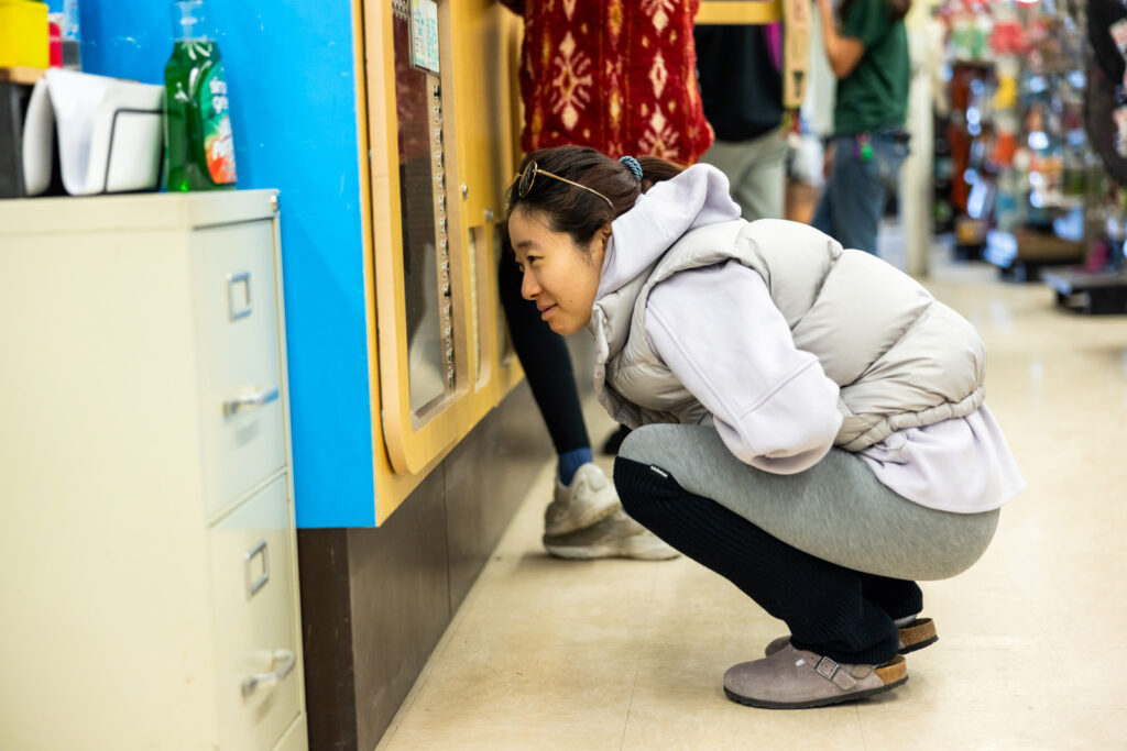 Woman looking at kittens during rescue adoption event by Cattails