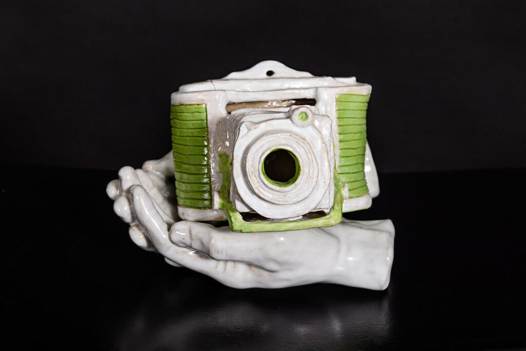 Hand sculpted ceramic hands and camera by Tammy Karin