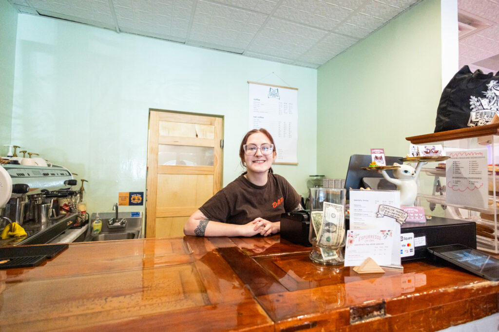 Espurresso employee poses at the Cat Cafe counter.