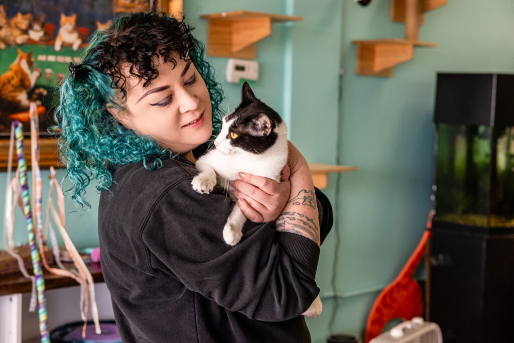 Sunflower pet employee getting cuddles in cat cafe