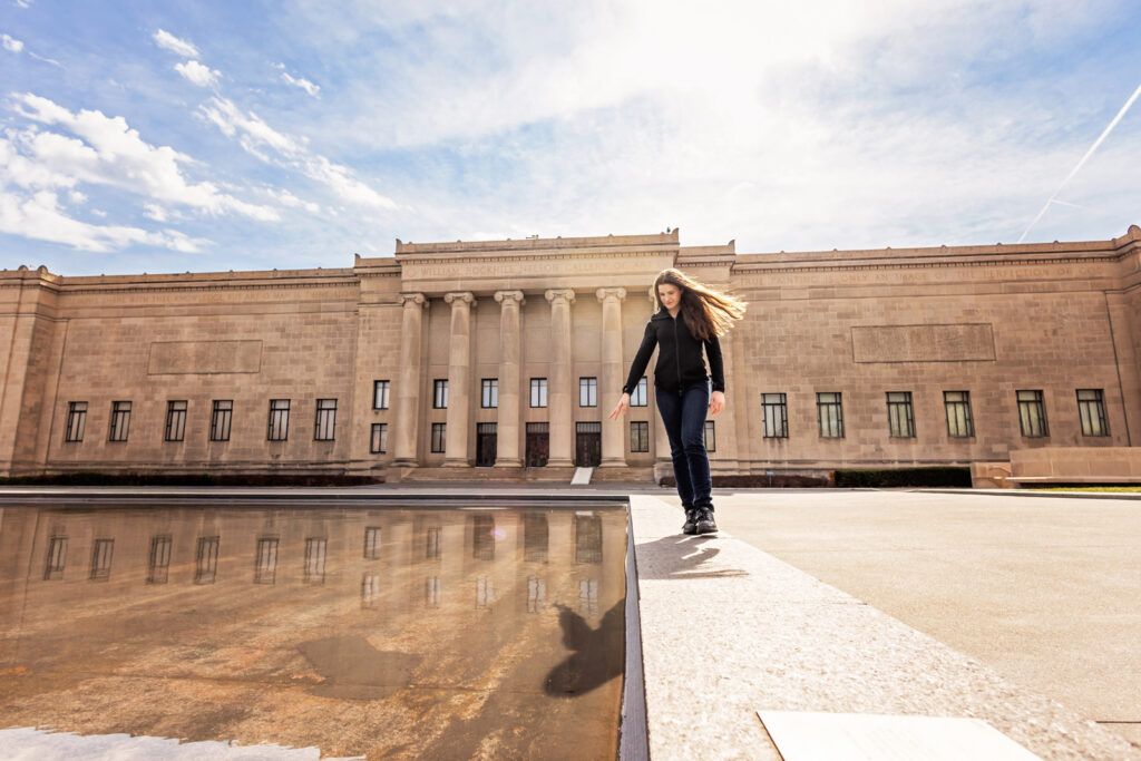 Artistic image of a young woman by the reflecting pool in front of the Nelson Atkins Museum in KC.