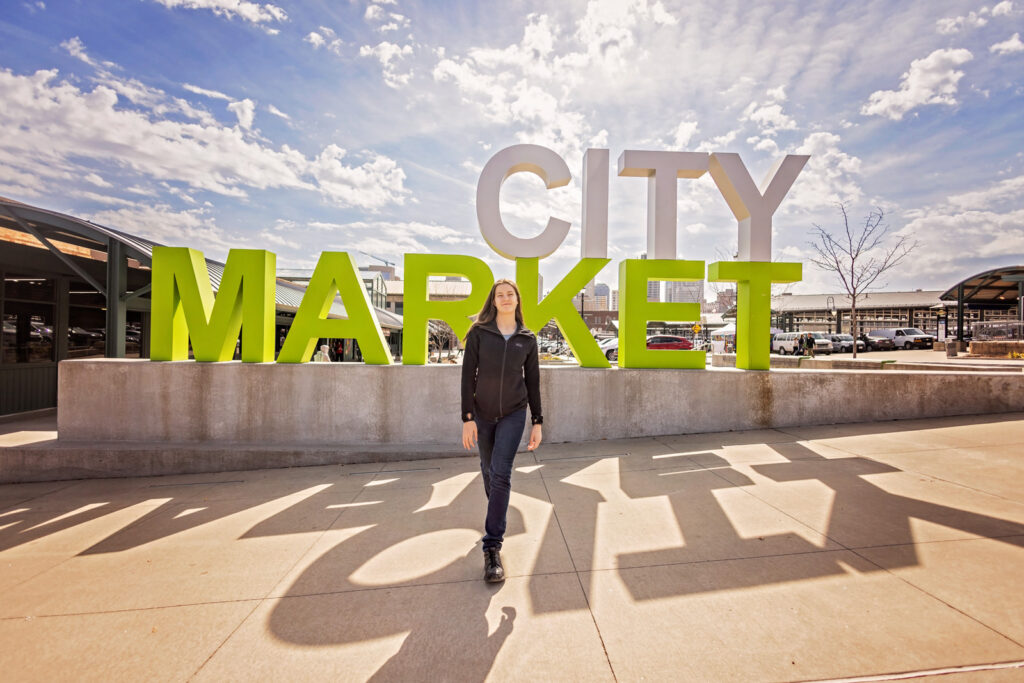 Casual senior photos with City Market sign in Kansas City.