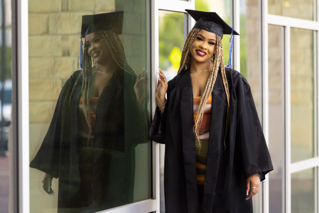 A high school senior posing against a modern glass and steel building in downtown Manhattan.
