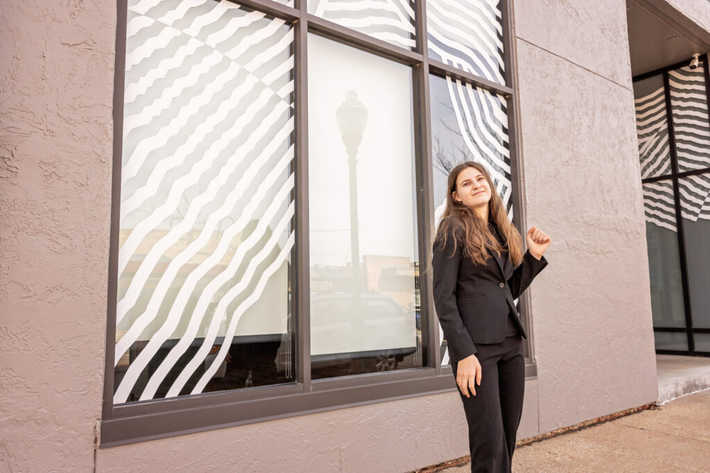 A senior portrait showcasing the eye catching Lawrence storefronts.